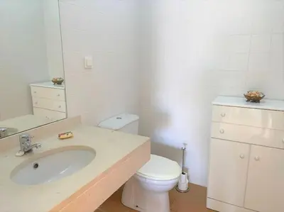 a bathroom with a toilet and a sink and a mirror at Desertrose in Porto Santo