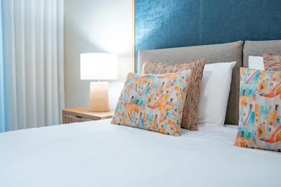 a bedroom with a white bed with pillows at Suite BM - 3 Pools-Gym-AC-Huge Balcony Sea View in Funchal