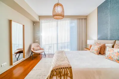 a bedroom with a large bed and a chair at Suite BM - 3 Pools-Gym-AC-Huge Balcony Sea View in Funchal