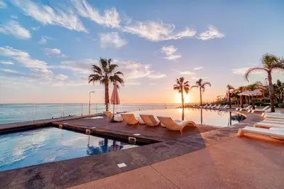 a swimming pool with palm trees and the ocean at Suite BM - 3 Pools-Gym-AC-Huge Balcony Sea View in Funchal