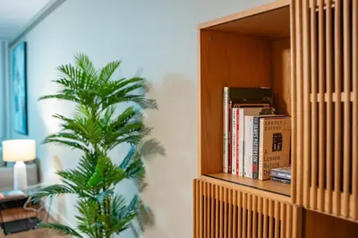 a book shelf with books and a plant in a room at Suite BM - 3 Pools-Gym-AC-Huge Balcony Sea View in Funchal