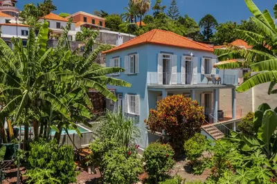 a blue house with an orange roof at Villa Quebra Costas by An Island Apart in Funchal