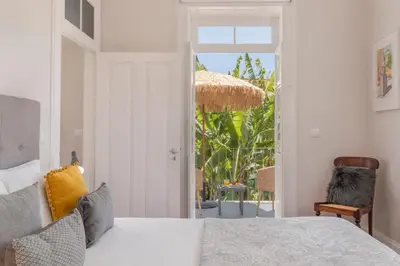 a bedroom with a bed and a view of a patio at Villa Quebra Costas by An Island Apart in Funchal