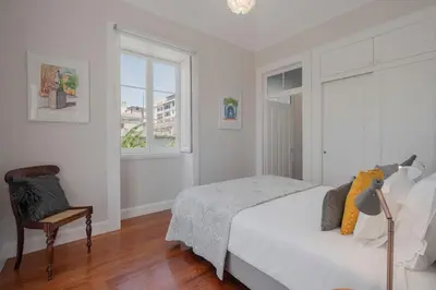a bedroom with a bed and a chair and a window at Villa Quebra Costas by An Island Apart in Funchal