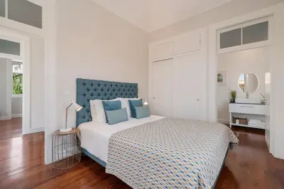 a bedroom with a bed with a blue headboard at Villa Quebra Costas by An Island Apart in Funchal