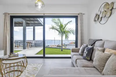 a living room with a couch and a view of the ocean at Landscape View by Homie in Canhas