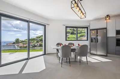 a dining room with a table and chairs and a large window at Landscape View by Homie in Canhas
