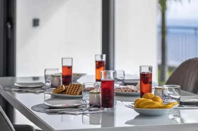 a table with plates of food and drinks on it at Landscape View by Homie in Canhas