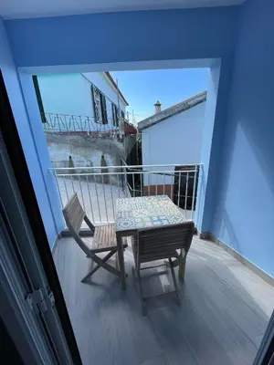 a balcony with a table and a chair on it at Tides proprety - Low tide in Paul do Mar