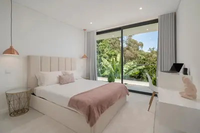 a bedroom with a bed and a large window at The White House by An Island Apart in Ponta do Sol