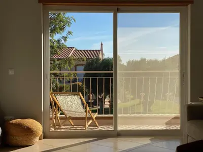 a sliding glass door with a chair on a balcony at A Casa Lagos, Golf in Lagos