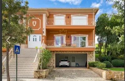 a large orange house with a car garage at A Casa Lagos, Golf in Lagos