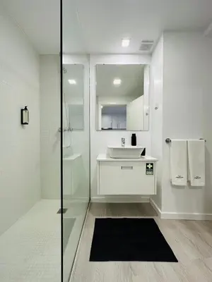 a white bathroom with a sink and a mirror at Living Funchal iNN in Funchal