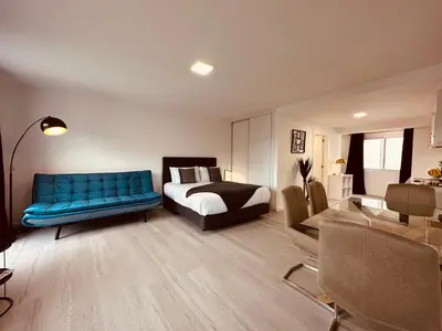 a bedroom with a bed and a blue couch at Living Funchal iNN in Funchal