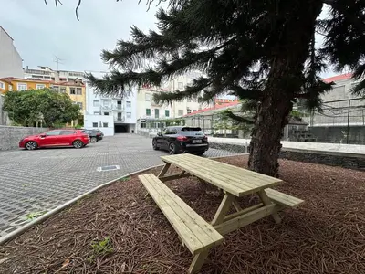 a wooden picnic table sitting next to a tree at Living Funchal iNN in Funchal