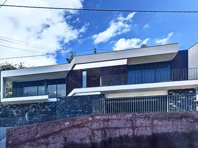 a modern house with a stone wall at Casa Dream 2 in Calheta