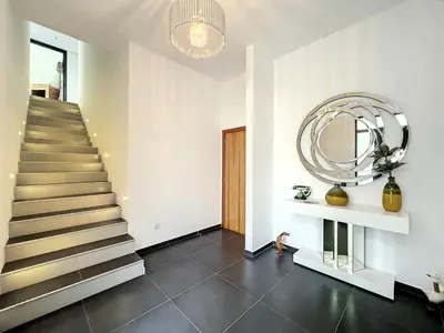 a hallway with a staircase and a round mirror at Casa Dream 2 in Calheta