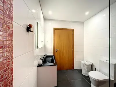 a bathroom with a toilet and a wooden door at Casa Dream 2 in Calheta
