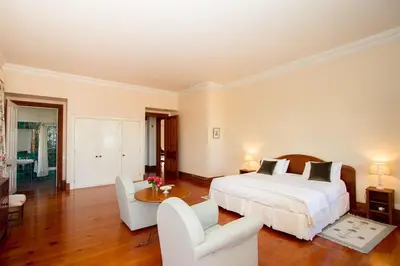 a bedroom with a bed and two chairs and a table at Villa Quinta Santa Luzia in Funchal