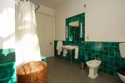 a green tiled bathroom with a toilet and a sink at Villa Quinta Santa Luzia in Funchal