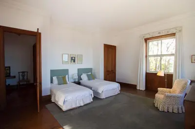 a bedroom with two beds and a chair and a window at Villa Quinta Santa Luzia in Funchal