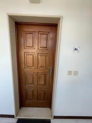 a wooden door in a white walled room with a door at O Nosso Recanto in Machico