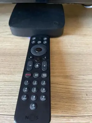 a remote control sitting on top of a wooden table at O Nosso Recanto in Machico
