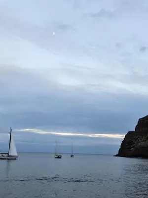 two boats in the water with a cloudy sky at O Nosso Recanto in Machico