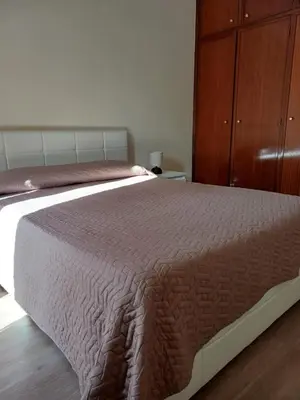 a bedroom with a large bed and a wooden cabinet at O Nosso Recanto in Machico