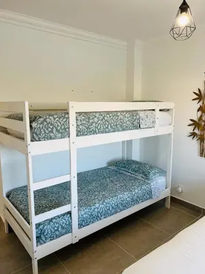 two bunk beds in a room with a lamp at New Flat surround by beaches. in Sagres