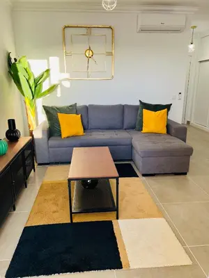 a living room with a blue couch and yellow pillows at New Flat surround by beaches. in Sagres