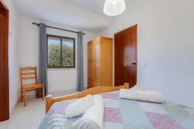 a bedroom with a bed and a window at Casa Teresinha - V028 in Montinhos da Luz