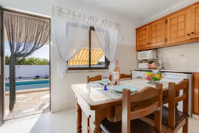 a kitchen with a table and chairs and a dining room at Casa Teresinha - V028 in Montinhos da Luz