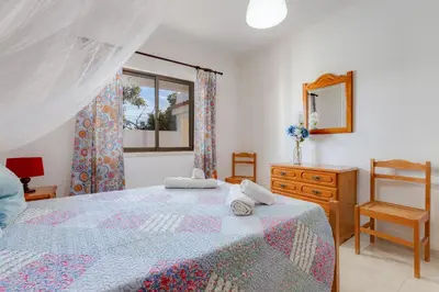 a bedroom with a bed and a dresser and a mirror at Casa Teresinha - V028 in Montinhos da Luz