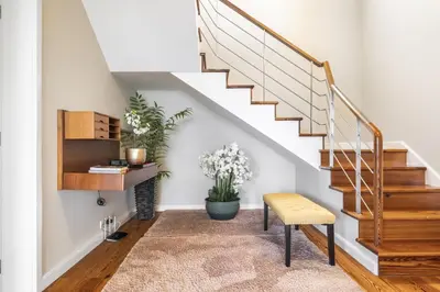 a hallway with stairs with a chair and a plant at Casa Olimpo by Homie in Estreito de Câmara de Lobos