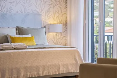 a bedroom with a bed with a yellow pillow at Casa Olimpo by Homie in Estreito de Câmara de Lobos