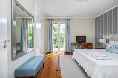 a bedroom with a bed and a mirror and a desk at Casa Olimpo by Homie in Estreito de Câmara de Lobos