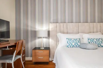 a bedroom with a bed with a desk and a television at Casa Olimpo by Homie in Estreito de Câmara de Lobos