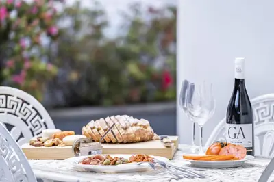 a table with a plate of food and a bottle of wine at Casa Olimpo by Homie in Estreito de Câmara de Lobos