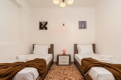a bedroom with two beds and a table with a lamp at Noite's House I - Prazeres in Prazeres