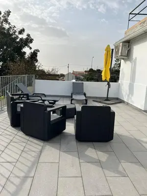 a patio with chairs and a table and a yellow umbrella at Noite's House I - Prazeres in Prazeres