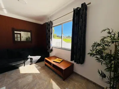 a living room with a couch and a table and a window at Noite's House I - Prazeres in Prazeres