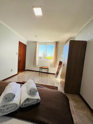 a bedroom with a bed with two towels on it at Noite's House I - Prazeres in Prazeres
