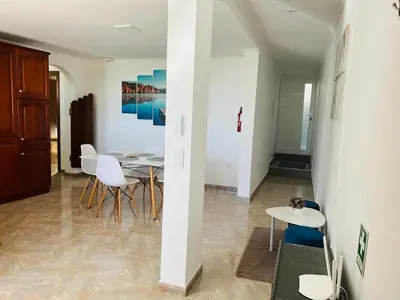 a dining room with white chairs and a table at Noite's House I - Prazeres in Prazeres