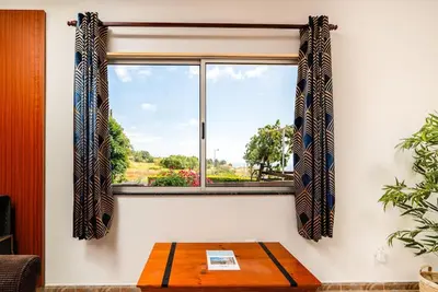 a window with a wooden table in front of it at Noite's House I - Prazeres in Prazeres