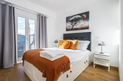 a white bedroom with a bed and a window at Il Tramonto by Homie in Ribeira Brava