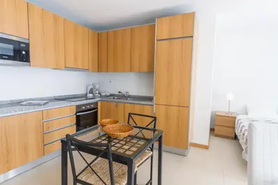 a kitchen with wooden cabinets and a table with baskets on it at Atlantic Sagres in Sagres