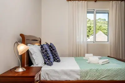 a bedroom with a bed with a lamp and a window at Casa do Palheiro Ribeirinho by Rent-a-key in Porto Moniz