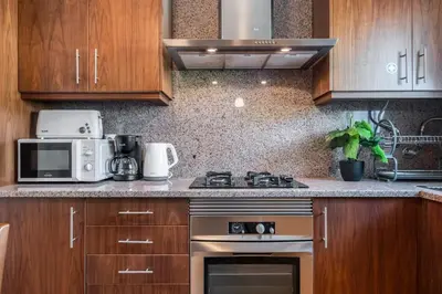 a kitchen with a stove and a microwave at Casa do Palheiro Ribeirinho by Rent-a-key in Porto Moniz