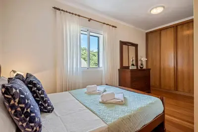 a bedroom with a bed with two towels on it at Casa do Palheiro Ribeirinho by Rent-a-key in Porto Moniz
